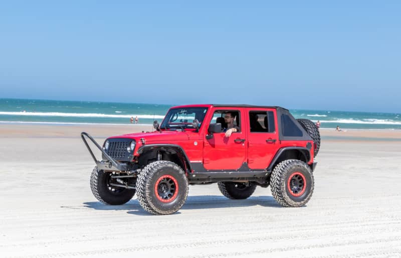 Jeep Beach Daytona Beach Red JK on shoreline with Nitto Trail Grapplers